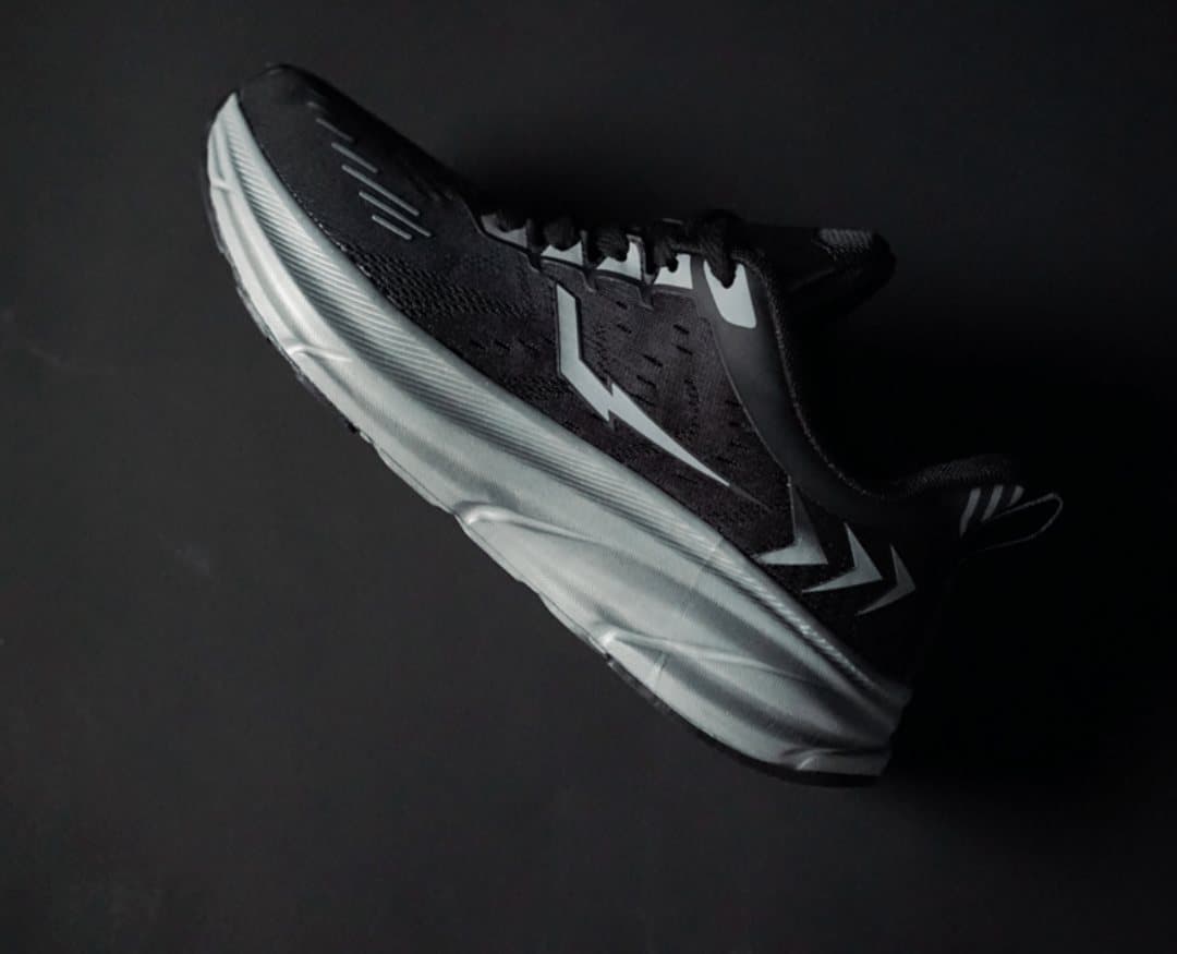 Black and grey Morph Lite runner on a dark studio background